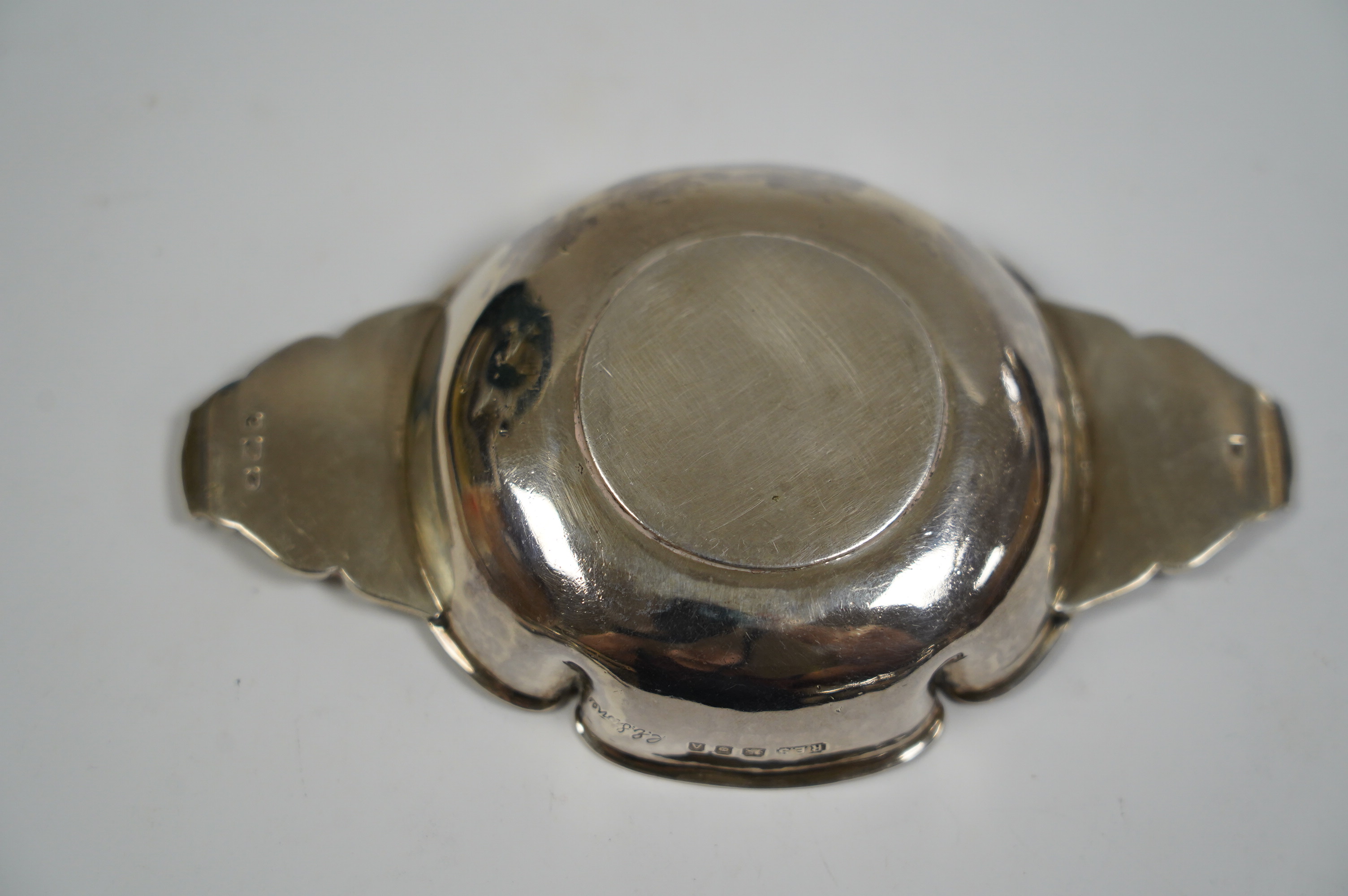 A George V foliate engraved silver quaich by Robert Edgar Stone, London, 1936, 12.2cm, together with a Norwegian 830 standard white metal articulated fish pill box, 60mm. Condition - fair to good